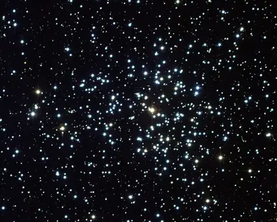 Der reiche offene Sternhaufen Messier 37 (NGC 2099) im Sternbild Fuhrmann mit dichtem Sternenfeld und einem rötlichen Stern im Zentrum.