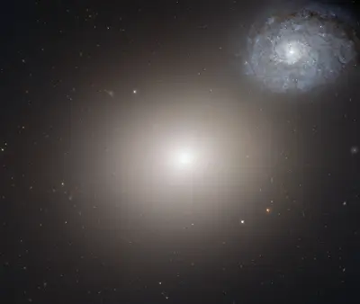 Hubble-Aufnahme der elliptischen Galaxie M60 neben der bläulichen Spiralgalaxie NGC 4647