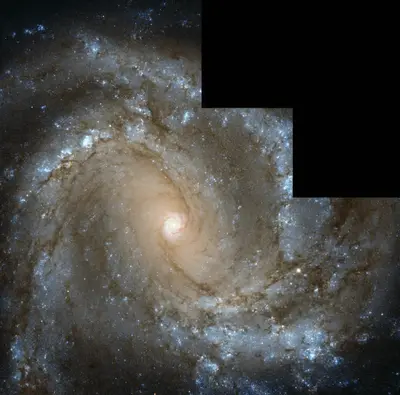 Hubble-Aufnahme der frontal sichtbaren Balkenspiralgalaxie M61 mit hellem Kern und blauen Sternentstehungsgebieten
