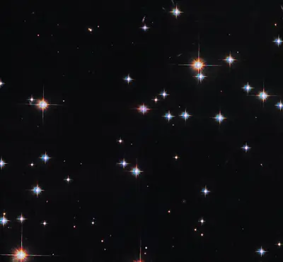 Hubble-Aufnahme eines Ausschnitts des offenen Sternhaufens M67 mit hellen weißen und rötlichen Sternen